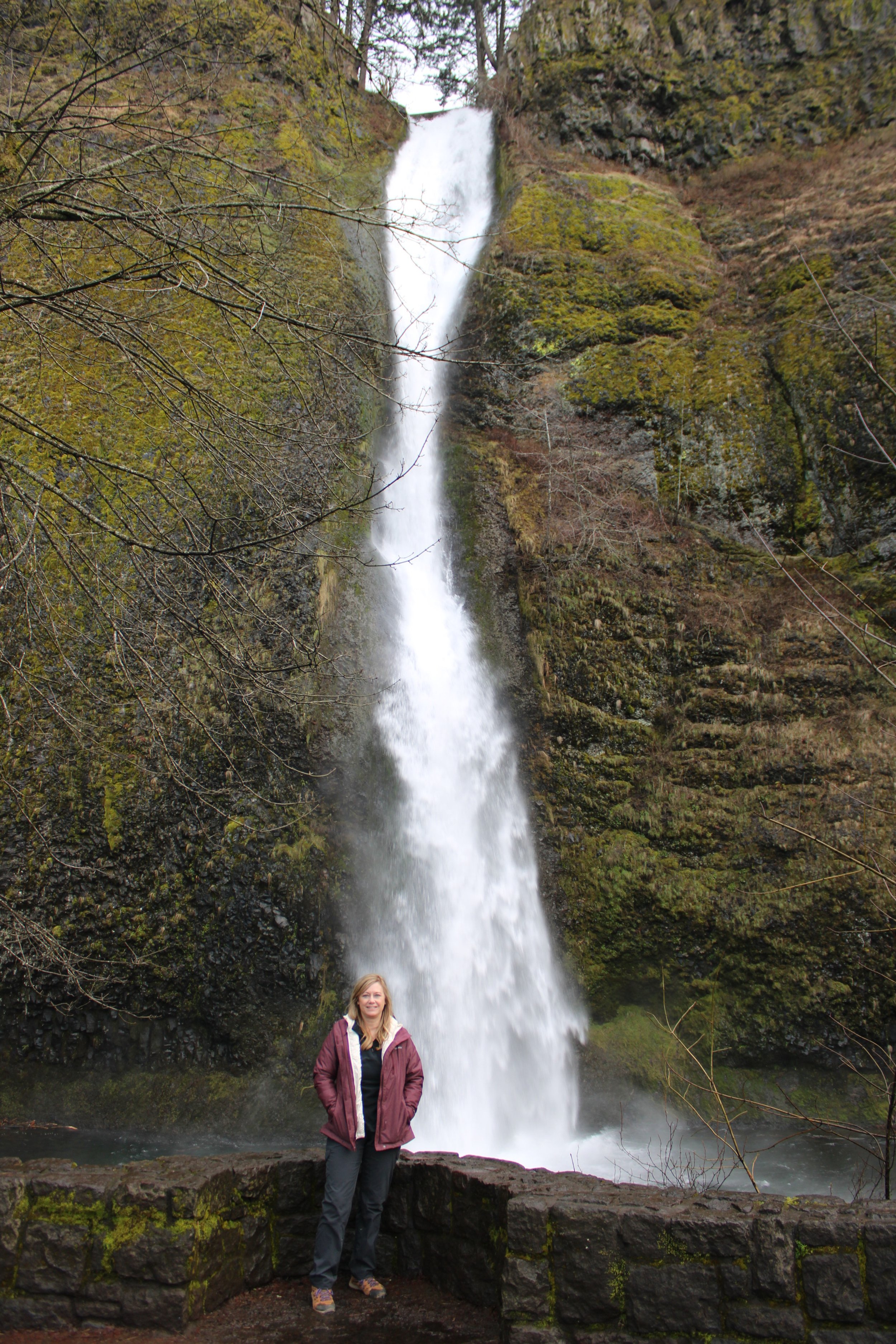 Lynna Arbogast standing beside a waterfall